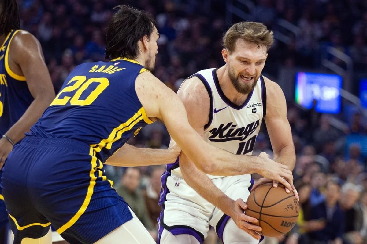 Jan 25, 2024; San Francisco, California, USA; Golden State Warriors center Dario Saric (20) tries to steal the ball from Sacramento Kings forward Domantas Sabonis (10) during the first quarter at Chase Center.