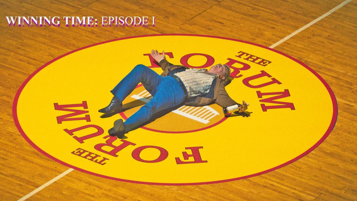 John C. Reilly as Jerry Buss, bottle in hand lays on the for of the Forum.