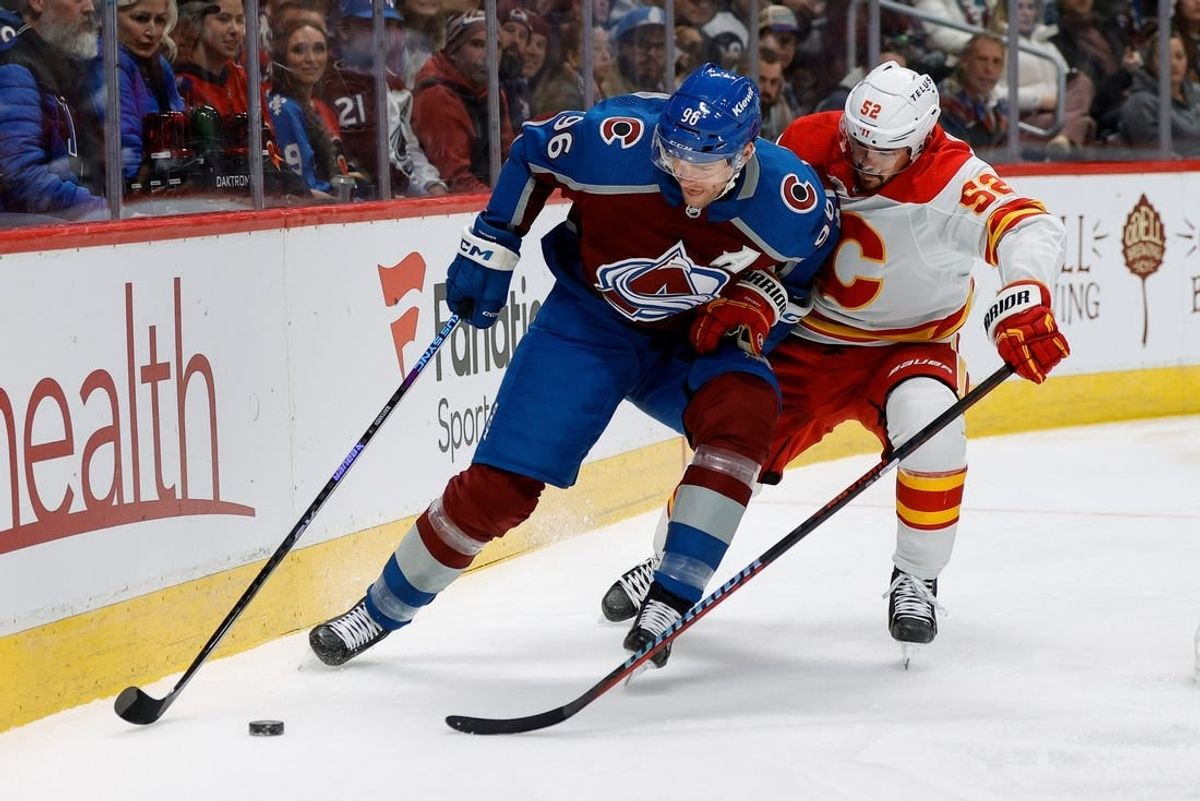 Nov 25, 2023; Denver, Colorado, USA; Colorado Avalanche right wing Mikko Rantanen (96) and Calgary Flames defenseman MacKenzie Weegar (52) battle for the puck in the first period at Ball Arena.