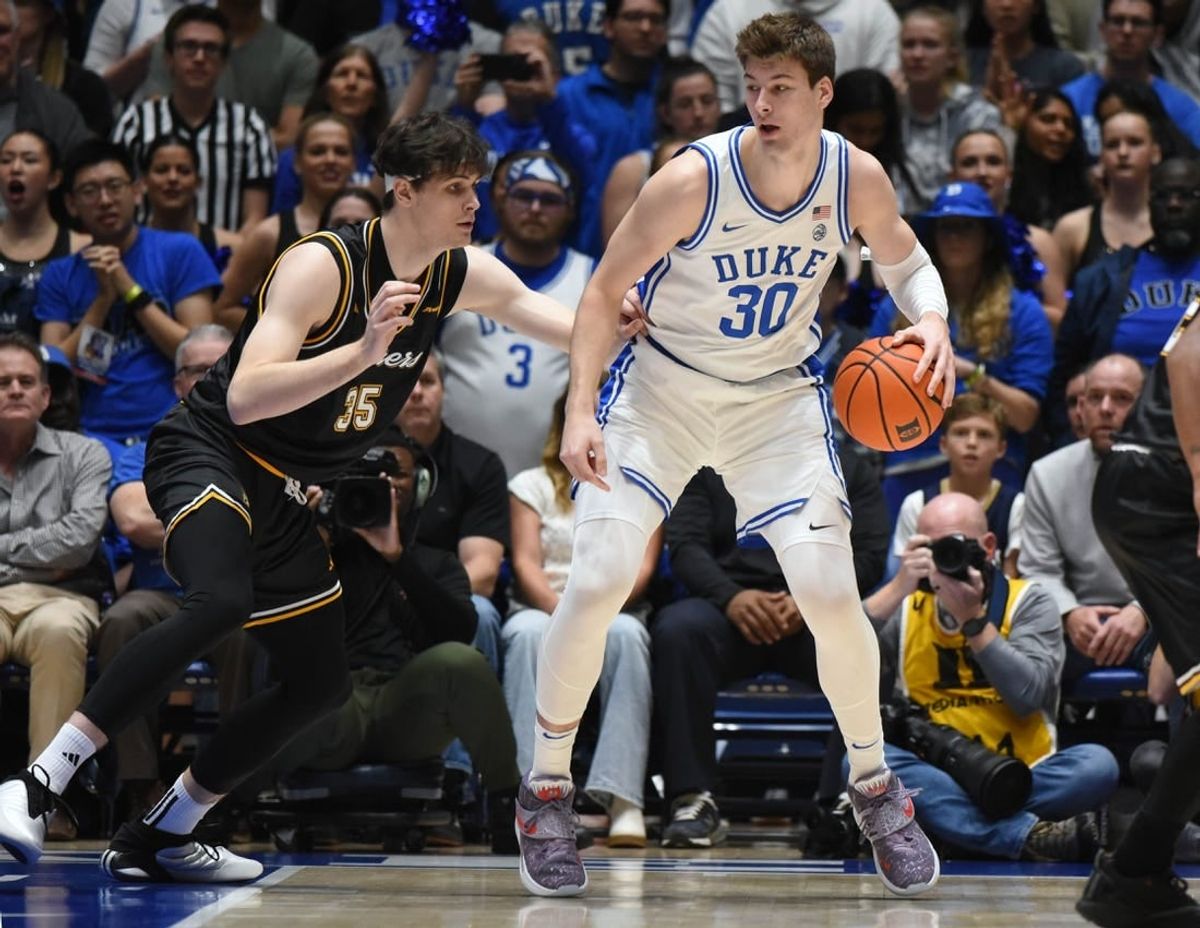 Nov 21, 2023; Durham, North Carolina, USA; Duke Blue Devils center Kyle Filipowski (30) controls the ball in front of La Salle Explorers forward Rokas Jucius (35) during the first half at Cameron Indoor Stadium.