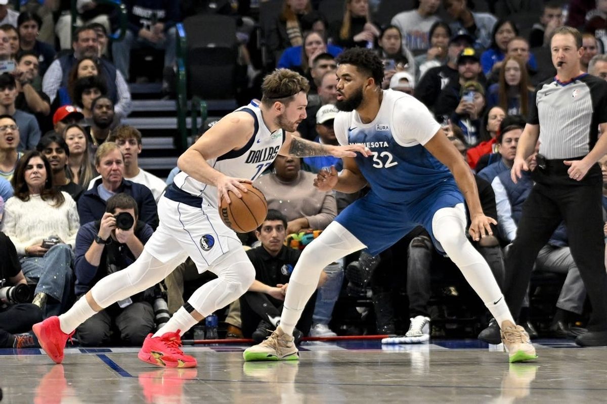 Jan 7, 2024; Dallas, Texas, USA; Dallas Mavericks guard Luka Doncic (77) drives to the basket past Minnesota Timberwolves center Karl-Anthony Towns (32) during the second quarter at the American Airlines Center.