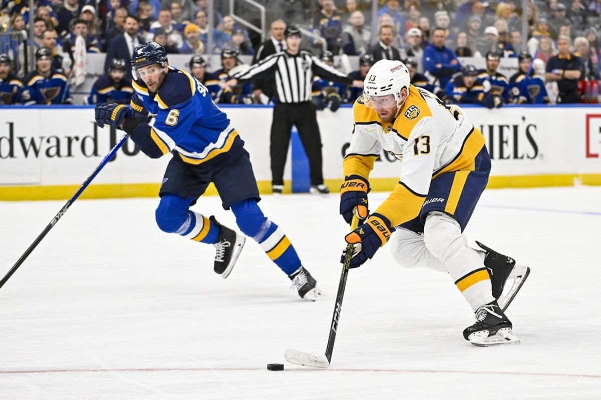 Nov 24, 2023; St. Louis, Missouri, USA;  Nashville Predators center Yakov Trenin (13) controls the puck against the St. Louis Blues during the first period at Enterprise Center.