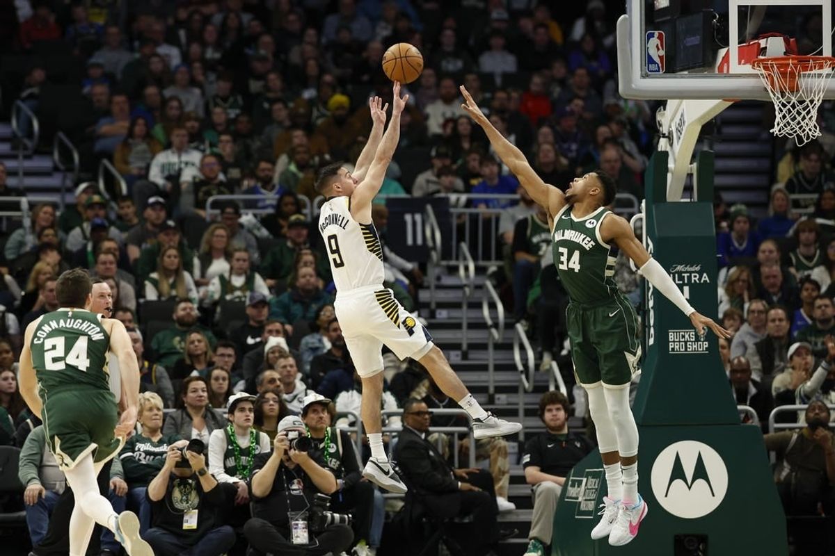 Indiana Pacers guard Tyrese Haliburton (0) shoots against Milwaukee Bucks forward Giannis Antetokounmpo (34) during the first half at Fiserv Forum.
