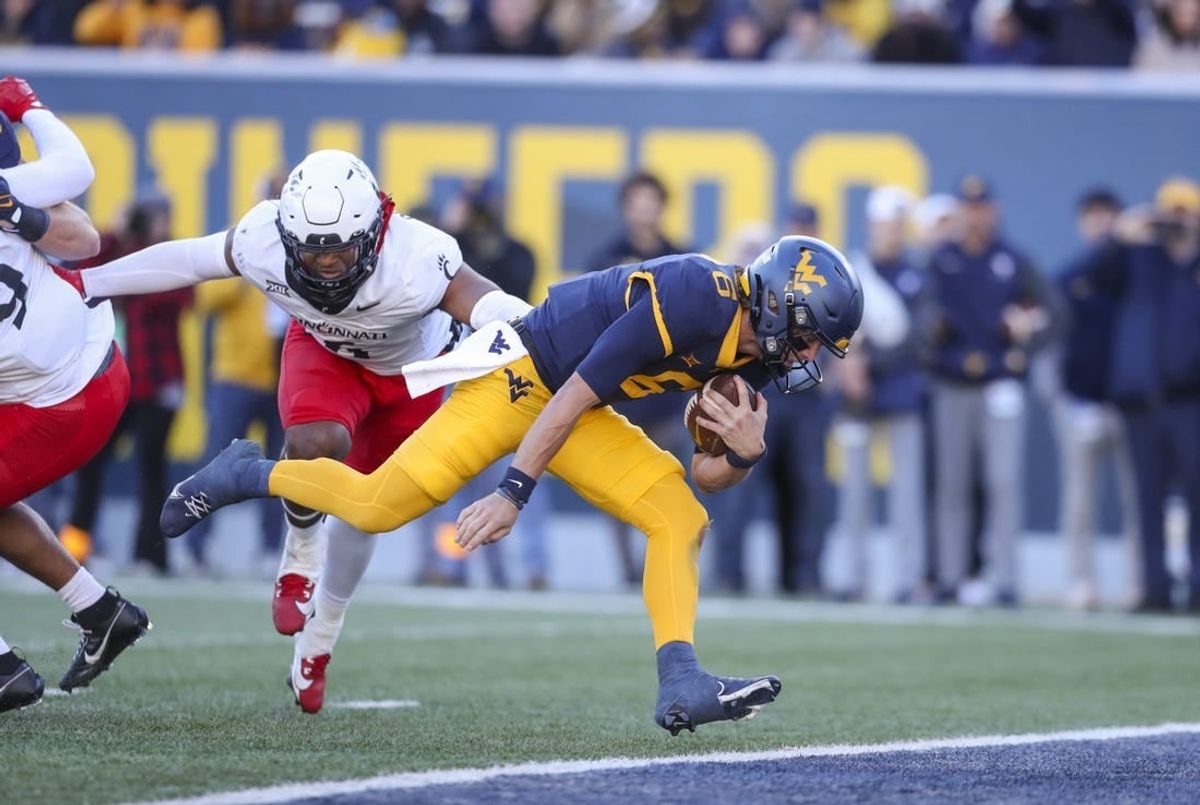 Nov 18, 2023; Morgantown, West Virginia, USA; West Virginia Mountaineers quarterback Garrett Greene (6) runs the ball for a touchdown during the first quarter against the Cincinnati Bearcats at Mountaineer Field at Milan Puskar Stadium.