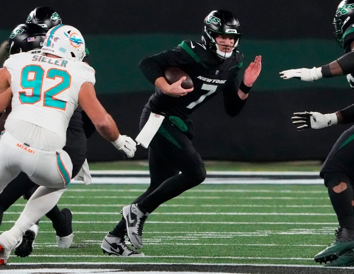 Nov 24, 2023; East Rutherford, New Jersey, USA; New York Jets quarterback Tim Boyle (7) scrambles against the Miami Dolphins in the second half at MetLife Stadium.