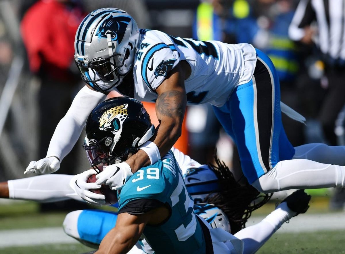 Jacksonville Jaguars wide receiver Jamal Agnew (39) gets tackled by Carolina Panthers cornerback Shaquill Griffin (20) and safety Vonn Bell (24) on a first down pass play to the 5-yard line late in the second quarter. Agnew was injured at the end of the play. The Jacksonville Jaguars hosted the Carolina Panthers at EverBank Stadium in Jacksonville, FL Sunday, December 31, 2023. The Jaguars went in at the half with a 9 to 0 lead. [Bob Self/Florida Times-Union]