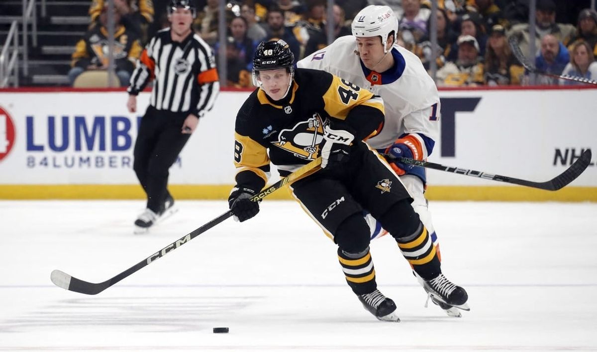 Dec 31, 2023; Pittsburgh, Pennsylvania, USA;  Pittsburgh Penguins right wing Valtteri Puustinen (48) moves the puck ahead of New York Islanders left wing Matt Martin (17) during the first period at PPG Paints Arena.
