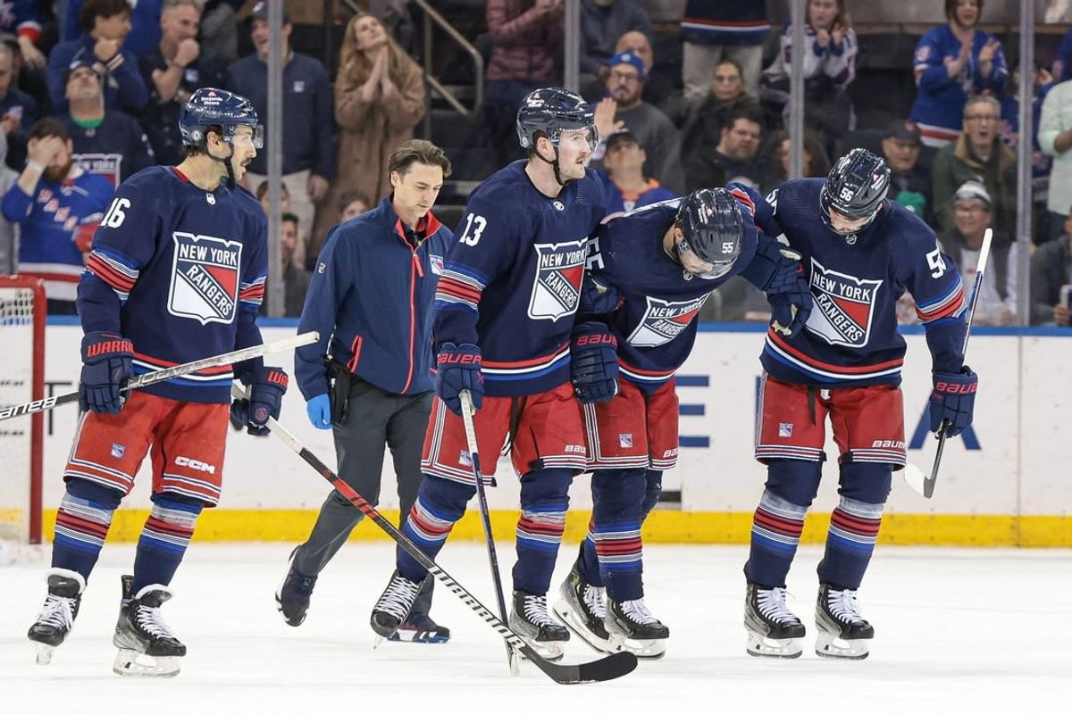 Mar 17, 2024; New York, New York, USA; New York Rangers defenseman Ryan Lindgren (55) is helped off the ice by teammates after an injury during the second period against the New York Islanders at Madison Square Garden.
