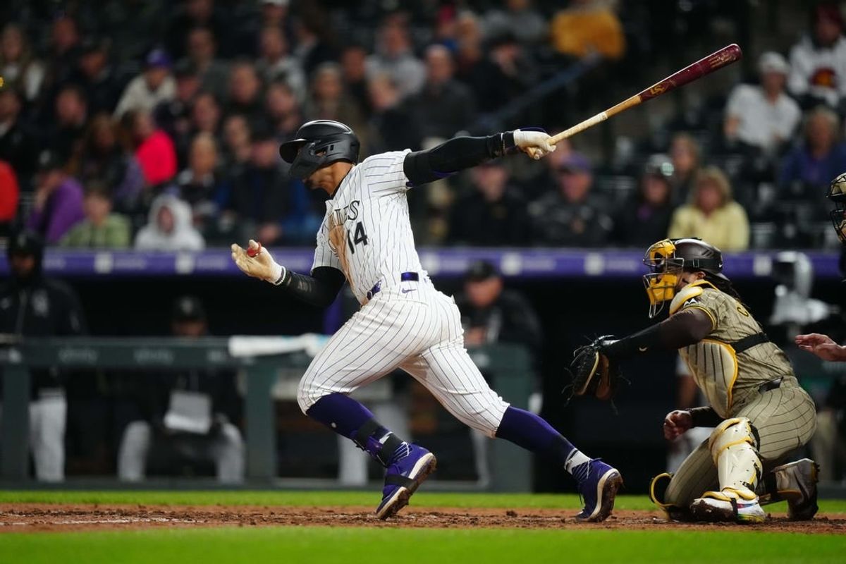 Apr 23, 2024; Denver, Colorado, USA; Colorado Rockies shortstop Ezequiel Tovar (14) hits an RBI single in the fifth inning against the San Diego Padres at Coors Field.