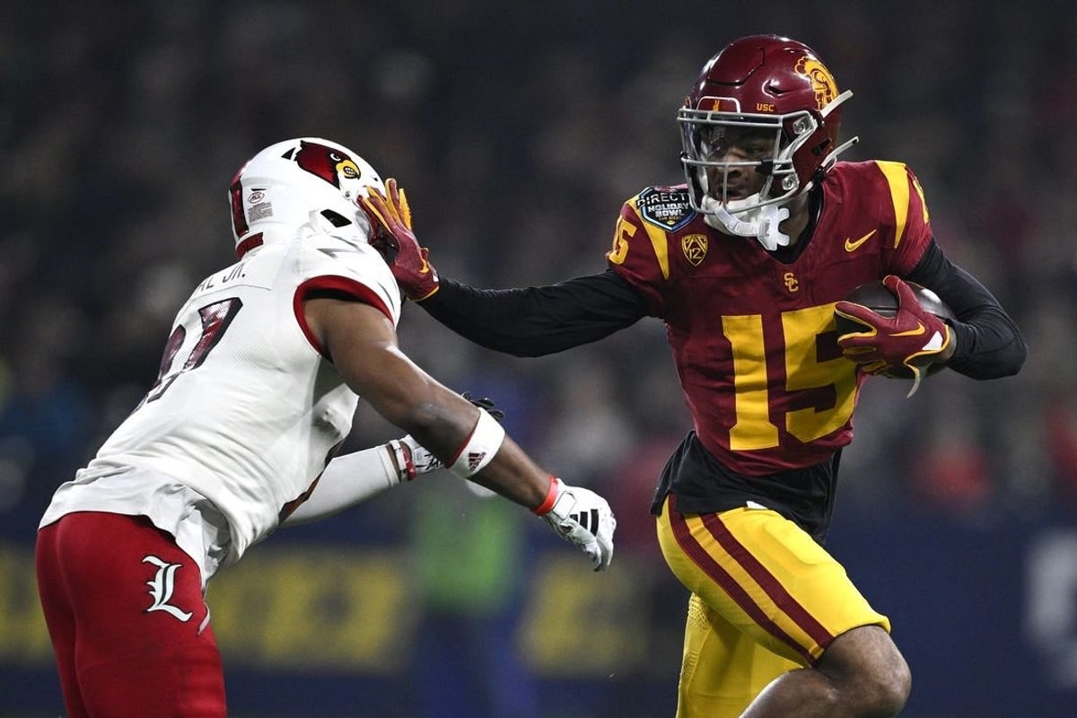 Dec 27, 2023; San Diego, CA, USA; USC Trojans wide receiver Dorian Singer (15) stiff arms Louisville Cardinals defensive back Devin Neal (27) during the first half at Petco Park.