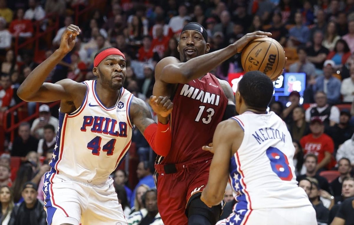 Dec 25, 2023; Miami, Florida, USA; Philadelphia 76ers forward Paul Reed (44) and  guard De'Anthony Melton (8) defend Miami Heat center Bam Adebayo (13) during the first half at Kaseya Center.