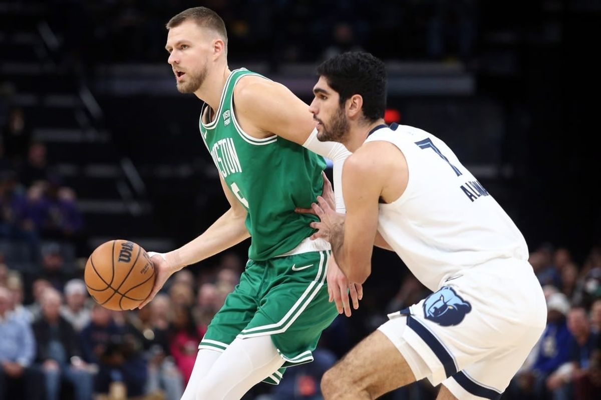 Nov 19, 2023; Memphis, Tennessee, USA; Boston Celtics center Kristaps Porzingis (8) passes as Memphis Grizzlies forward-center Santi Aldama (7) defends during the first half at FedExForum.