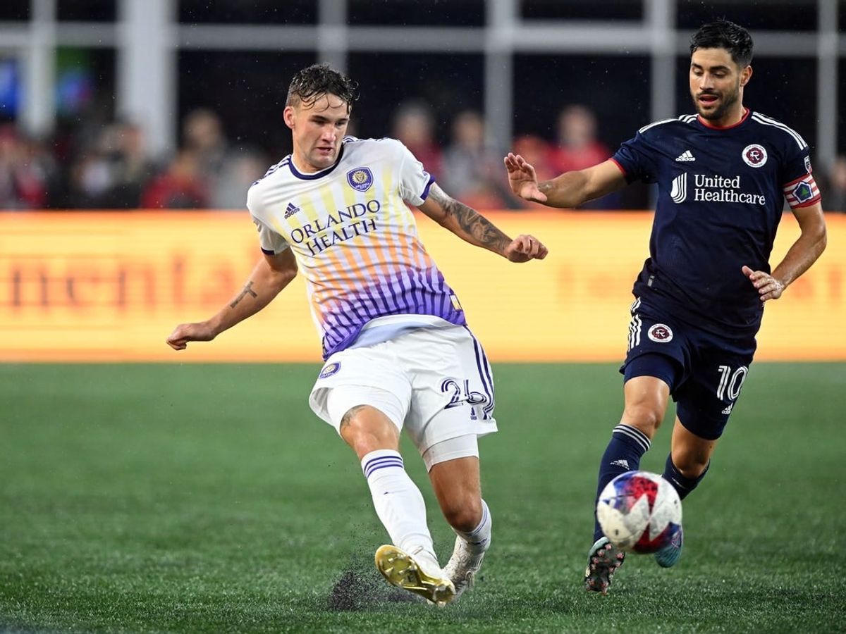 Jun 17, 2023; Foxborough, Massachusetts, USA; Orlando City defender Michael Halliday (26) passes the ball in front of New England Revolution midfielder Carles Gil (10) during the first half of a match at Gillette Stadium.
