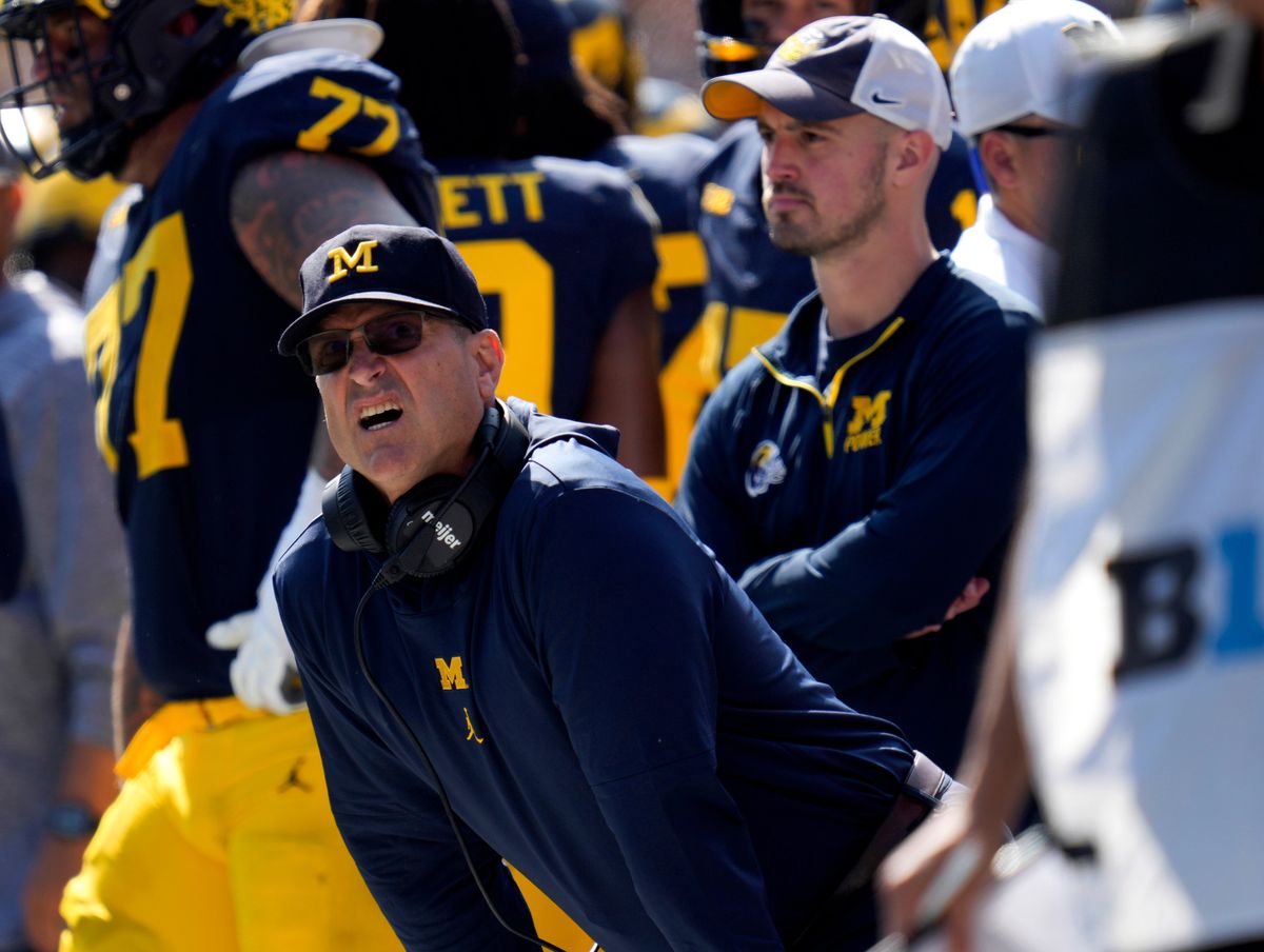 Jim Harbaugh (l.) and Connor Stalions (center)