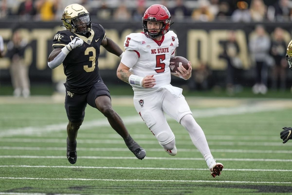 Nov 11, 2023; Winston-Salem, North Carolina, USA;  North Carolina State Wolfpack quarterback Brennan Armstrong (5) tries to outrun Wake Forest Demon Deacons defensive back Malik Mustapha (3) during the first half at Allegacy Federal Credit Union Stadium.