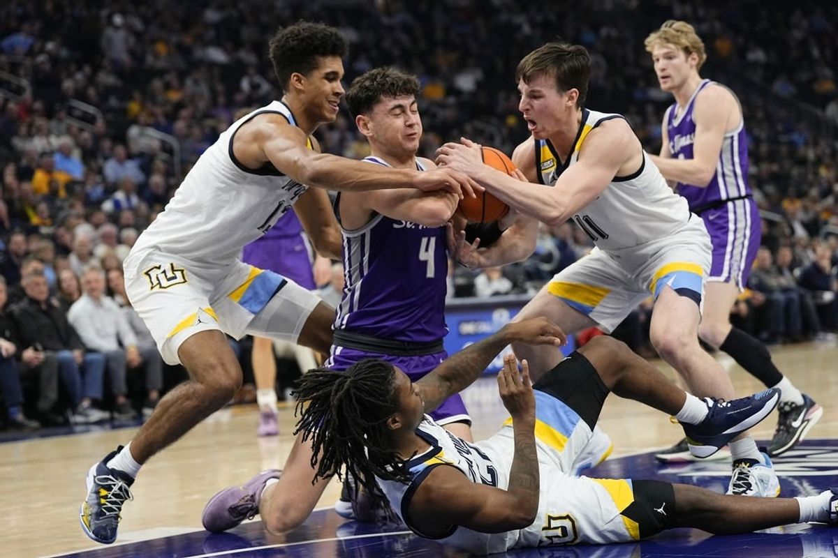 Dec 14, 2023; Milwaukee, Wisconsin, USA;  St. Thomas (MN) Tommies forward Brooks Allen (4) battles Marquette Golden Eagles forward Oso Ighodaro (13) and guard Tyler Kolek (11) for control of the ball during the first half at Fiserv Forum.