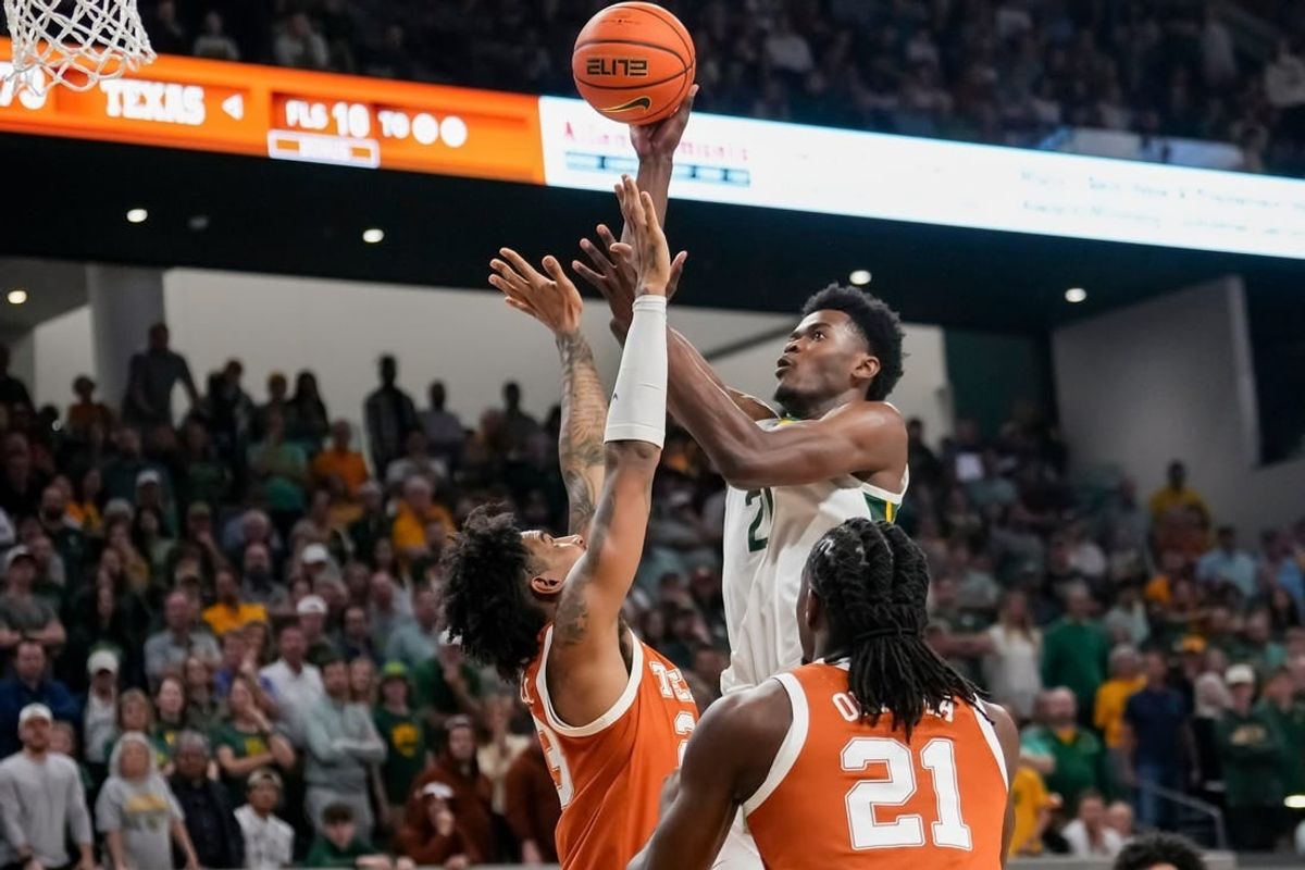Mar 4, 2024; Waco, Texas, USA;  Baylor Bears center Yves Missi (21) scores a basket over Texas Longhorns forward Dillon Mitchell (23) during the second half at Paul and Alejandra Foster Pavilion.