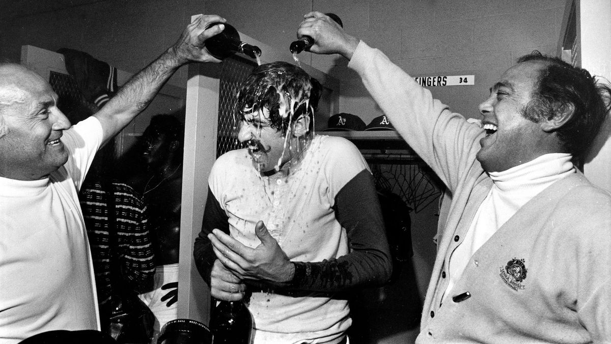 Oakland Athletics relief pitcher Rollie Fingers gets drenched in champagne during victory celebrations in the dressing room after winning the World Series in Cincinnati, Ohio, Oct. 22, 1972. Photo credit:  [object Object]