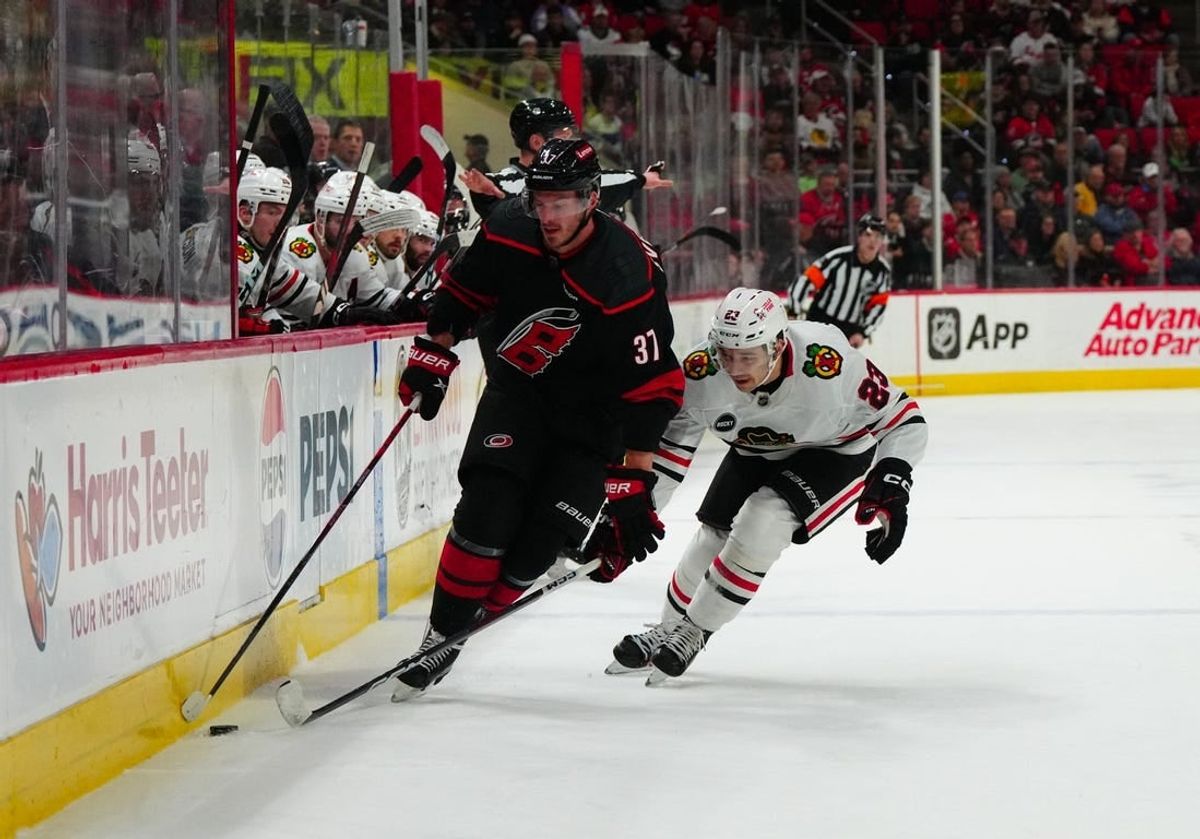 Feb 19, 2024; Raleigh, North Carolina, USA;  Carolina Hurricanes right wing Andrei Svechnikov (37) skates with the puck past Chicago Blackhawks center Philipp Kurashev (23) during the first period at PNC Arena.