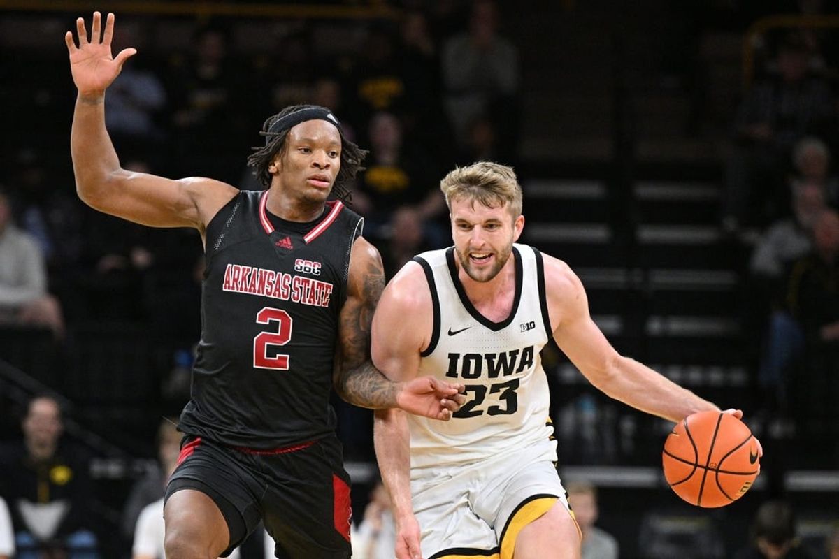Nov 17, 2023; Iowa City, Iowa, USA; Iowa Hawkeyes forward Ben Krikke (23) controls the ball as Arkansas State Red Wolves guard Freddy Hicks (2) defends during the first half at Carver-Hawkeye Arena.