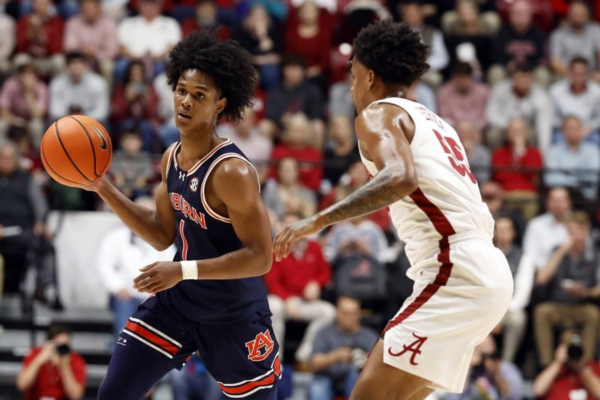 Jan 24, 2024; Tuscaloosa, Alabama, USA; Auburn Tigers guard Aden Holloway (1) dribbles around Alabama Crimson Tide guard Aaron Estrada (55) during the first half at Coleman Coliseum.