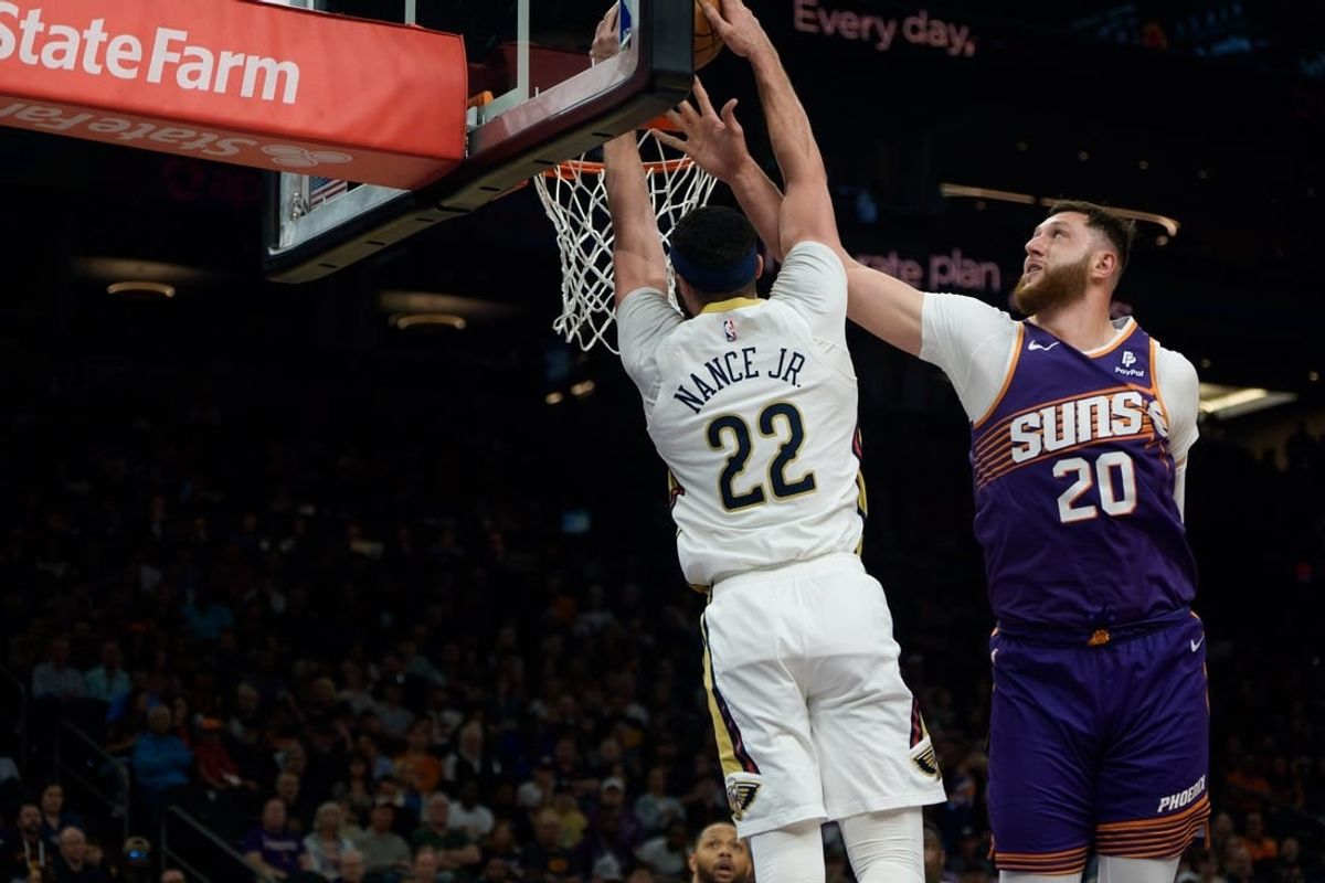 Apr 7, 2024; Phoenix, Arizona, USA;  New Orleans Pelicans forward-center Larry Nance Jr. (22) dunks over Phoenix Suns center Jusuf Nurkic (20) during the first half at Footprint Center.