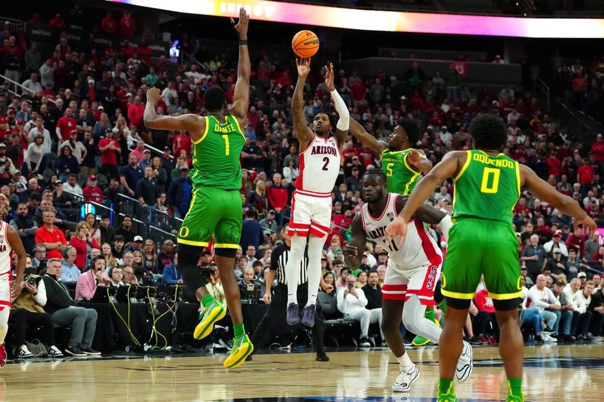 Mar 15, 2024; Las Vegas, NV, USA; Arizona Wildcats guard Caleb Love (2) shoots between Oregon Ducks center N'Faly Dante (1) and Oregon Ducks guard Jermaine Couisnard (5) during the second half at T-Mobile Arena.
