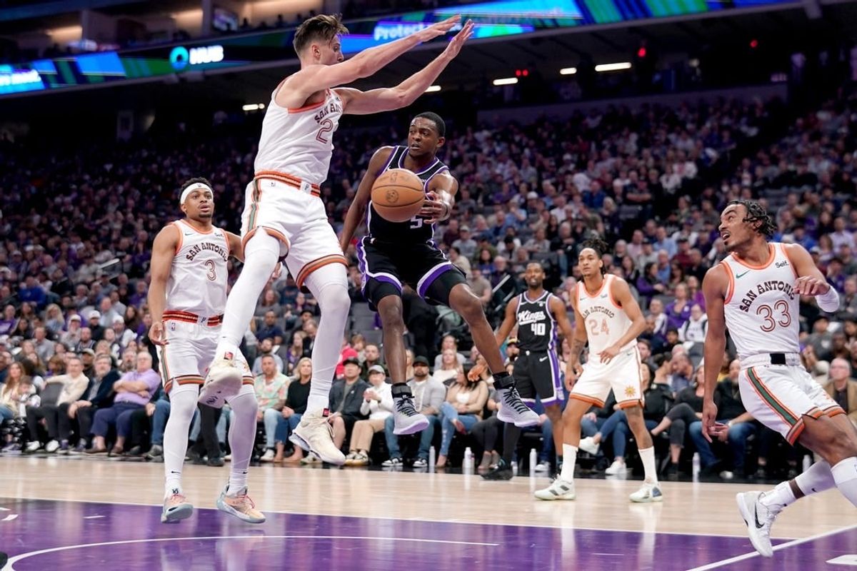 Mar 7, 2024; Sacramento, California, USA; Sacramento Kings guard De'Aaron Fox (5) passes the ball around the reach of San Antonio Spurs forward Zach Collins (23) in the second quarter at the Golden 1 Center.