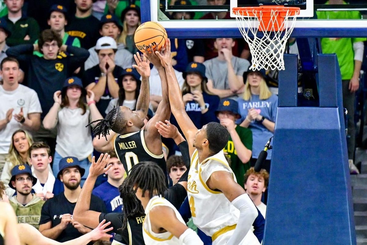 Feb 27, 2024; South Bend, Indiana, USA; Wake Forest Demon Deacons guard Kevin Miller (0) goes up for a shot as Notre Dame Fighting Irish forward Kebba Njie (14) defends in the second half at the Purcell Pavilion.