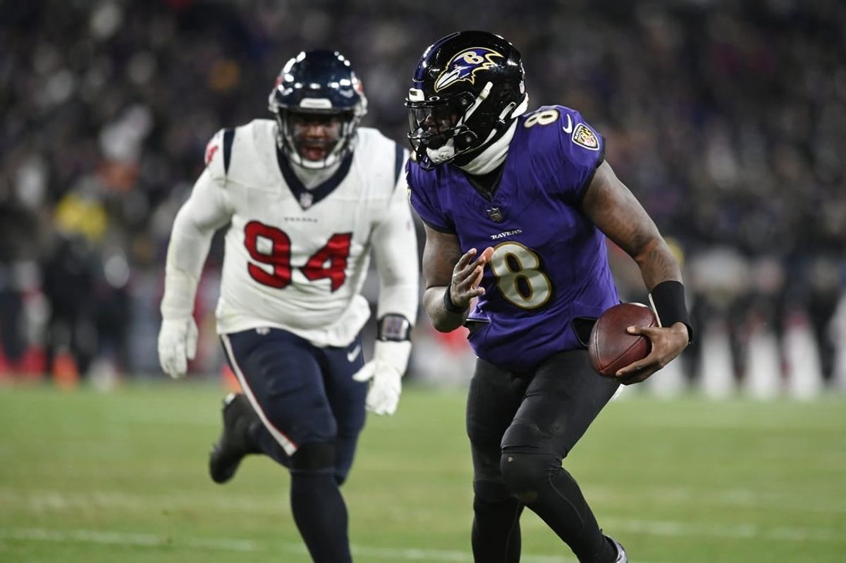 Jan 20, 2024; Baltimore, MD, USA; Baltimore Ravens quarterback Lamar Jackson (8) runs the ball to score a touchdown against Houston Texans defensive tackle Khalil Davis (94) during the fourth quarter of a 2024 AFC divisional round game at M&T Bank Stadium.