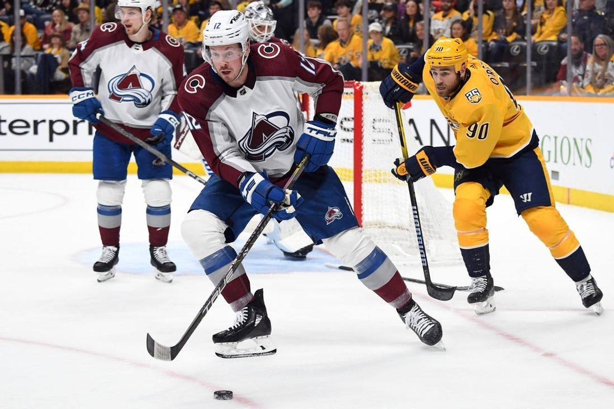 Mar 2, 2024; Nashville, Tennessee, USA; Colorado Avalanche center Ryan Johansen (12) gathers a loose puck during the third period against the Nashville Predators at Bridgestone Arena.