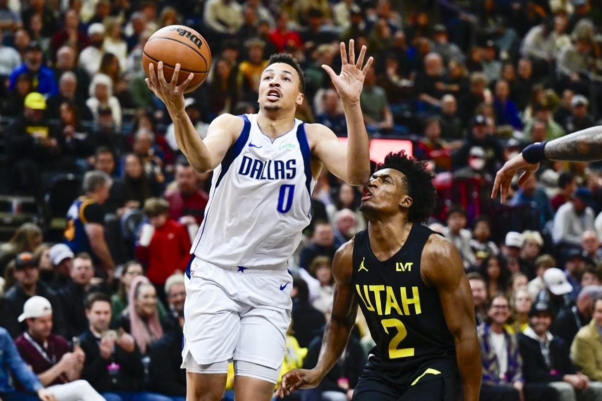 Jan 1, 2024; Salt Lake City, Utah, USA; Dallas Mavericks guard Dante Exum (0) takes a shot in front of Utah Jazz guard Collin Sexton (2) during the first half at the Delta Center.