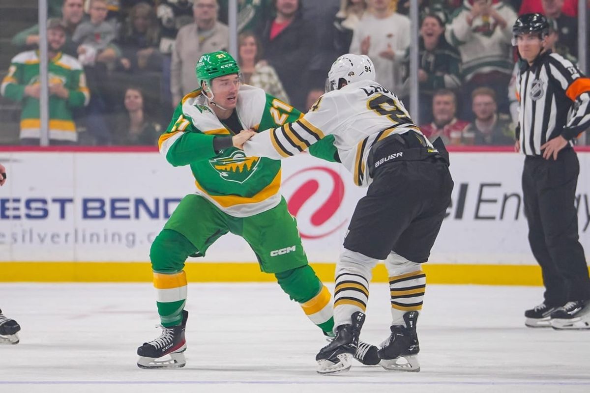 Dec 23, 2023; Saint Paul, Minnesota, USA; Minnesota Wild right wing Brandon Duhaime (21) and Boston Bruins center Jakub Lauko (94) fight  in the first period at Xcel Energy Center.