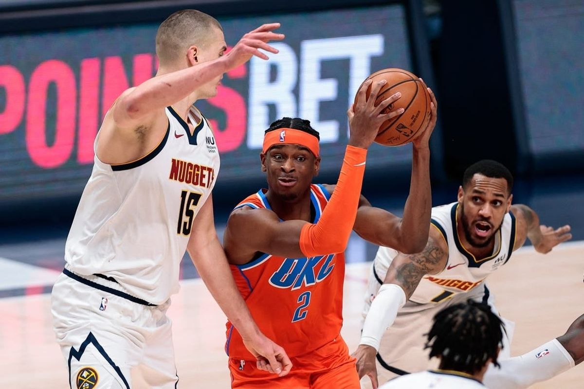 Jan 19, 2021; Denver, Colorado, USA; Oklahoma City Thunder guard Shai Gilgeous-Alexander (2) controls the ball against Denver Nuggets center Nikola Jokic (15) and guard Monte Morris (11) in the third quarter at Ball Arena.