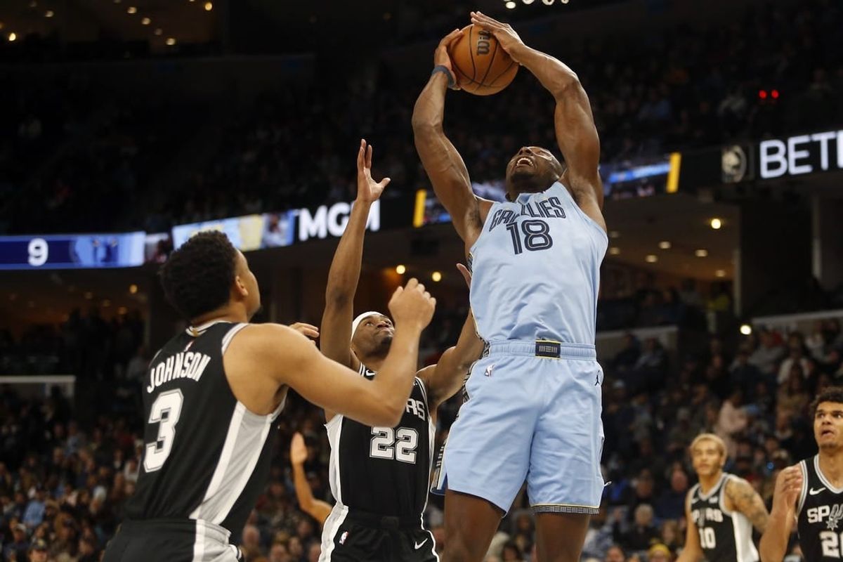 Jan 2, 2024; Memphis, Tennessee, USA; Memphis Grizzlies center Bismack Biyombo (18) collects a rebound over San Antonio Spurs guard Malaki Branham (22) during the first half at FedExForum.