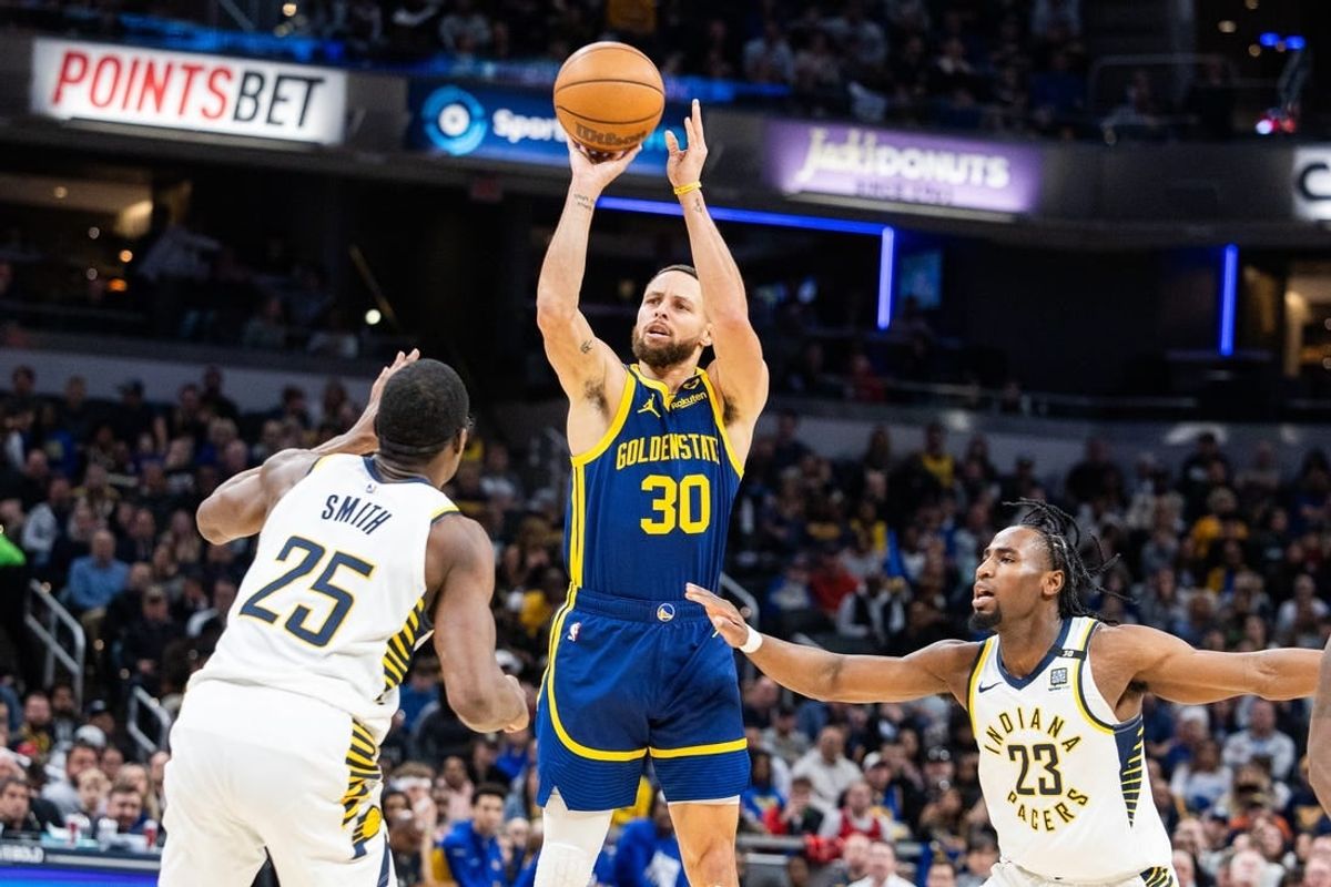 Feb 8, 2024; Indianapolis, Indiana, USA; Golden State Warriors guard Stephen Curry (30) shoots the ball while Indiana Pacers forward Jalen Smith (25) and forward Aaron Nesmith (23)  defend in the first half at Gainbridge Fieldhouse.