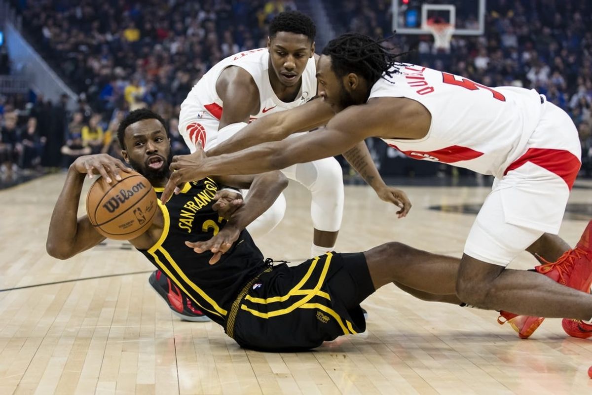 Jan 7, 2024; San Francisco, California, USA;  Golden State Warriors forward Andrew Wiggins (22) and Toronto Raptors guard Immanuel Quickley (5) and forward RJ Barrett (9) battle for possession during the first half at Chase Center.