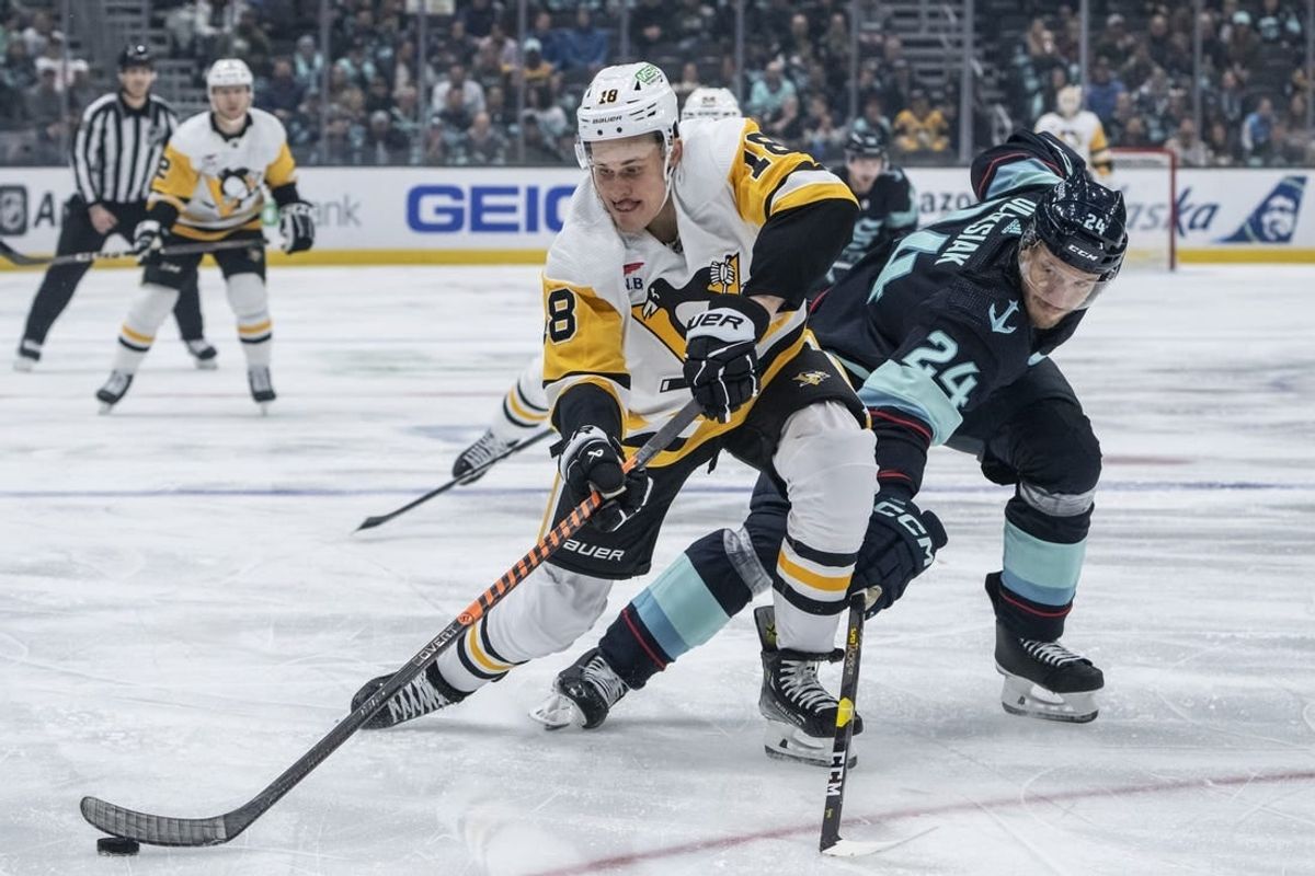 Feb 29, 2024; Seattle, Washington, USA; Pittsburgh Penguins forward Jesse Puljujarvi (18) and Seattle Kraken defenseman Jamie Oleksiak (24) battle for the puck during the first period at Climate Pledge Arena.