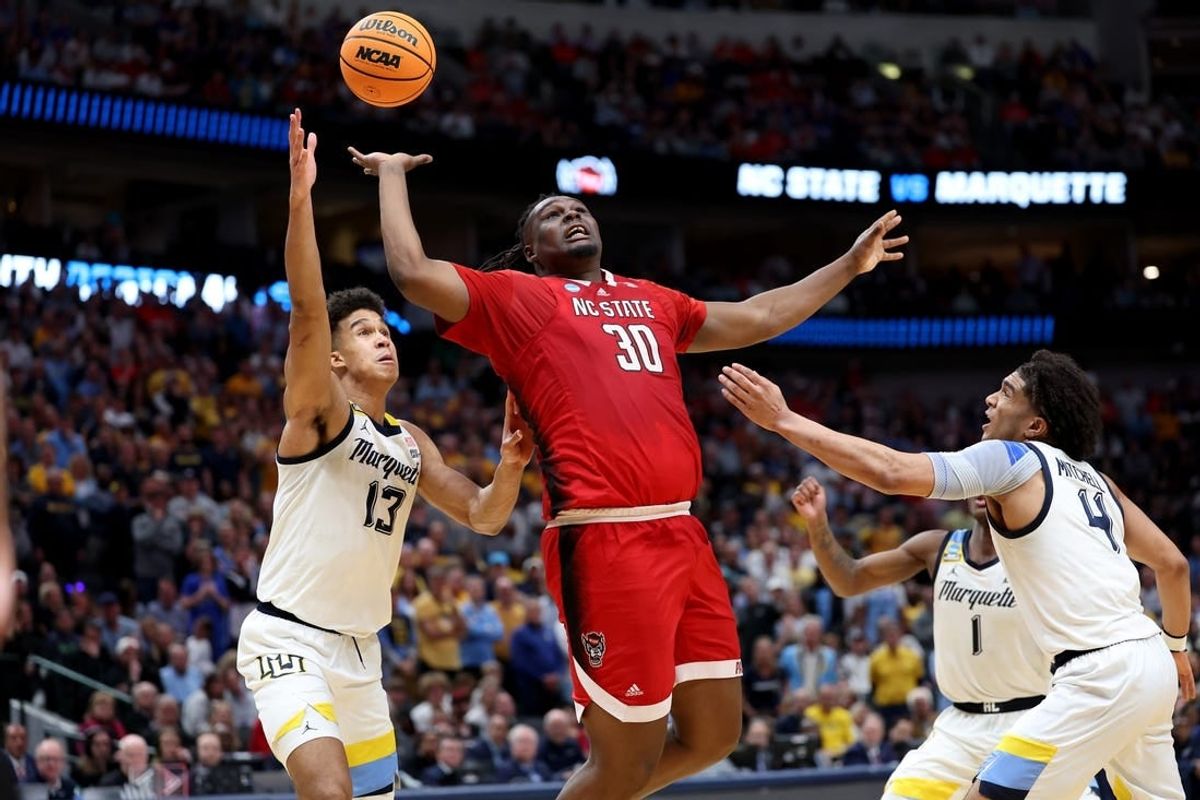 Mar 29, 2024; Dallas, TX, USA; North Carolina State Wolfpack forward DJ Burns Jr. (30) rebounds against Marquette Golden Eagles forward Oso Ighodaro (13),  guard Kam Jones (1) and guard Stevie Mitchell (4) during the second half in the semifinals of the South Regional of the 2024 NCAA Tournament at American Airlines Center.