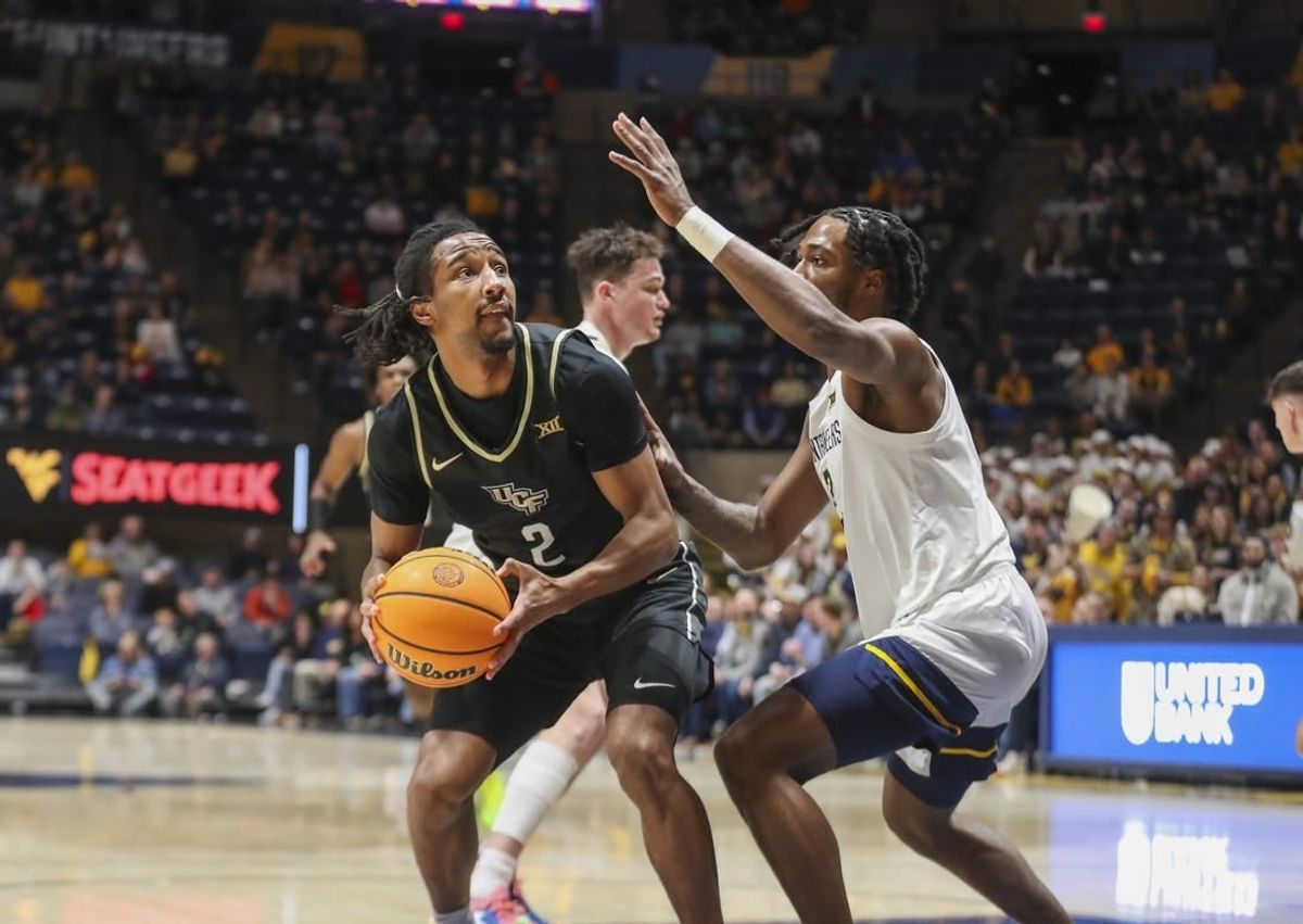 Feb 20, 2024; Morgantown, West Virginia, USA; UCF Knights guard Shemarri Allen (2) shoots against West Virginia Mountaineers guard Kobe Johnson (2) during the first half at WVU Coliseum.