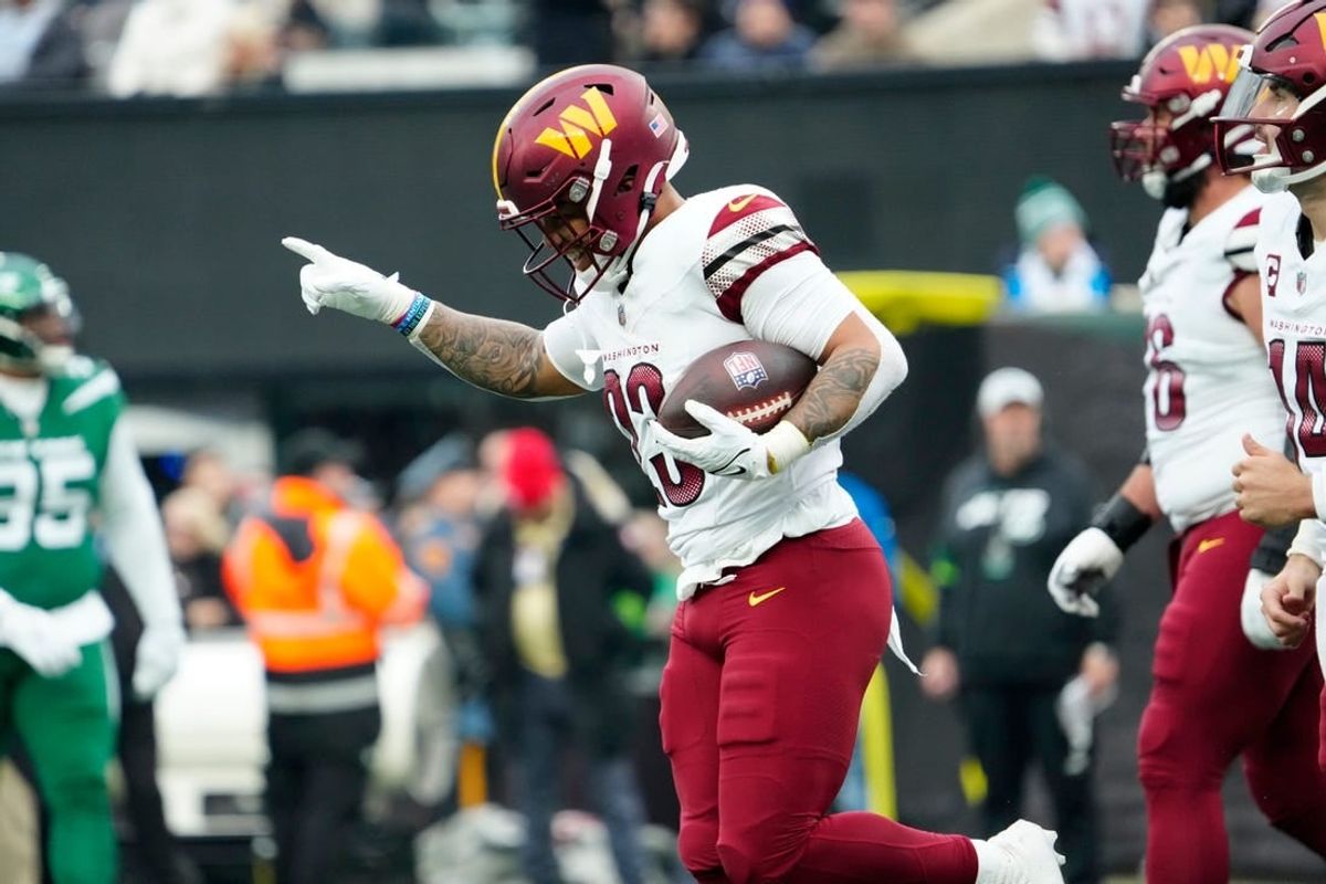 Washington Commanders running back Chris Rodriguez Jr. (23), celebrates seconds after scoring the only touchdown for his team in the first half, Sunday December 24, 2023.