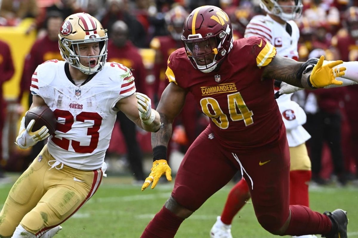 Dec 31, 2023; Landover, Maryland, USA; San Francisco 49ers running back Christian McCaffrey (23) carries the ball as Washington Commanders defensive tackle Daron Payne (94) during the second half at FedExField.