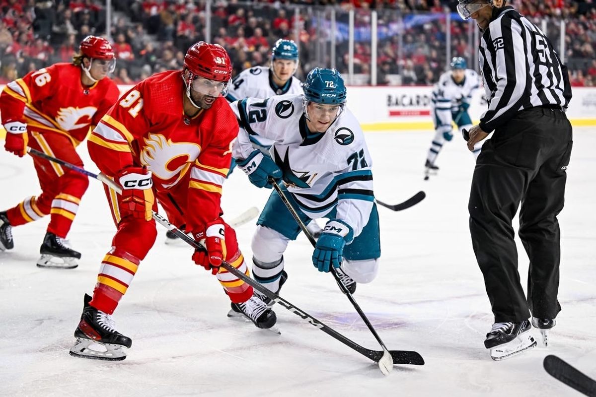 Feb 15, 2024; Calgary, Alberta, CAN; Calgary Flames center Nazem Kadri (91) and San Jose Sharks left wing William Eklund (72) take a face-off during the first period at Scotiabank Saddledome.