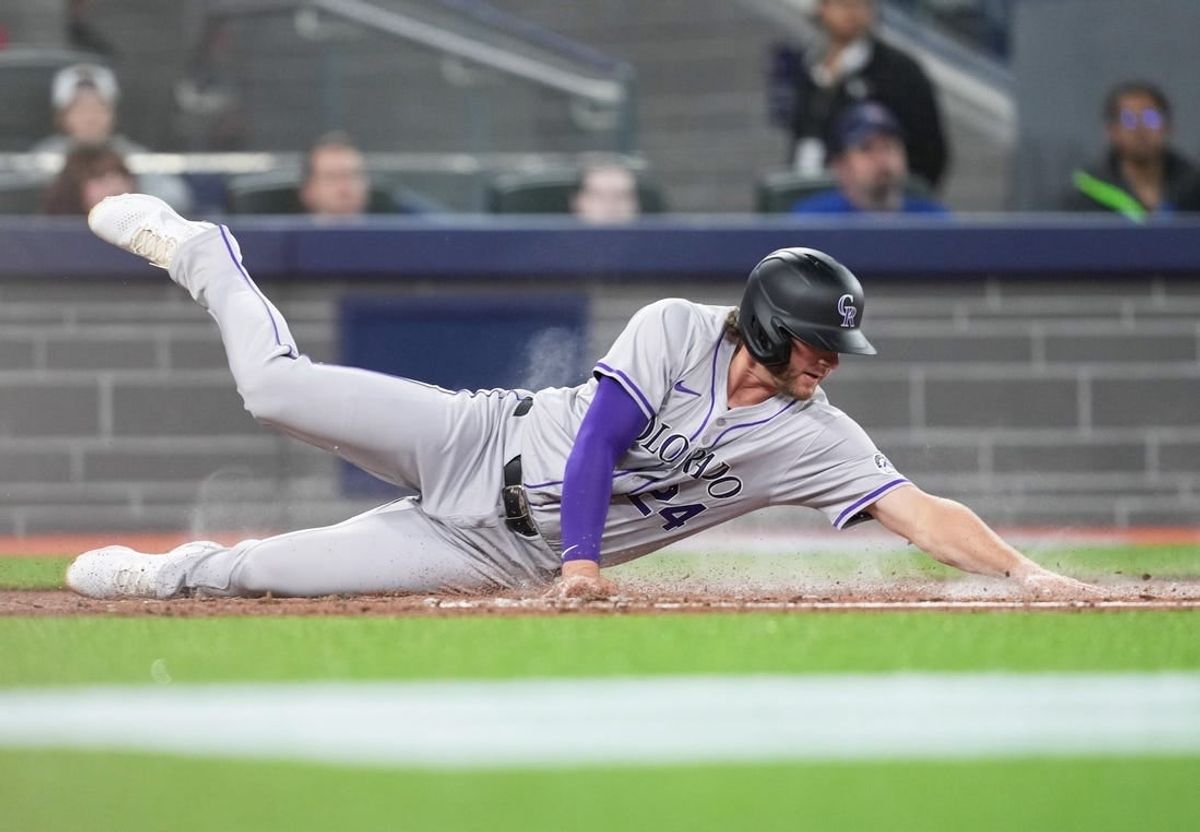Apr 12, 2024; Toronto, Ontario, CAN; Colorado Rockies third baseman Ryan McMahon (24) scores a run against the Toronto Blue Jays during the third inning at Rogers Centre.