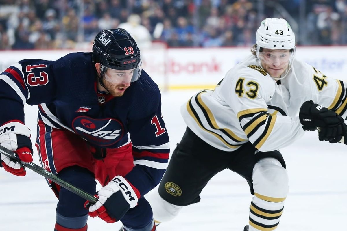 Dec 22, 2023; Winnipeg, Manitoba, CAN;  Winnipeg Jets forward Gabriel Vilardi (13) and Boston Bruins forward Danton Heinen (43) skate after the puck during the first period at Canada Life Centre.