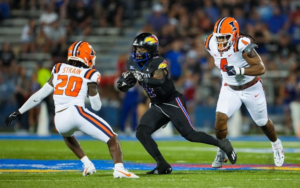 Sep 8, 2023; Lawrence, Kansas, USA; Kansas Jayhawks running back Devin Neal (4) runs the ball against Illinois Fighting Illini defensive back Tyler Strain (20) and defensive lineman Jer'Zhan Newton (4) during the second half at David Booth Kansas Memorial Stadium.