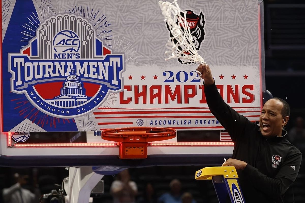 Mar 16, 2024; Washington, D.C., USA; North Carolina State Wolfpack head coach Kevin Keatts reacts by cutting the net from the basketball rim after defeating the North Carolina Tar Heels at Capital One Arena.