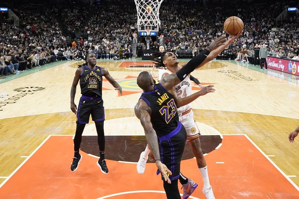 Dec 15, 2023; San Antonio, Texas, USA; San Antonio Spurs guard Devin Vassell (24) drives to the basket against Los Angeles Lakers forward LeBron James (23) during the second half at Frost Bank Center.