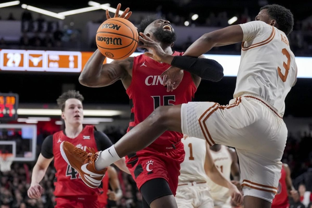 Jan 9, 2024; Cincinnati, Ohio, USA;  Cincinnati Bearcats forward John Newman III (15) reacts as he is fouled by Texas Longhorns guard Max Abmas (3) in the first half at Fifth Third Arena.