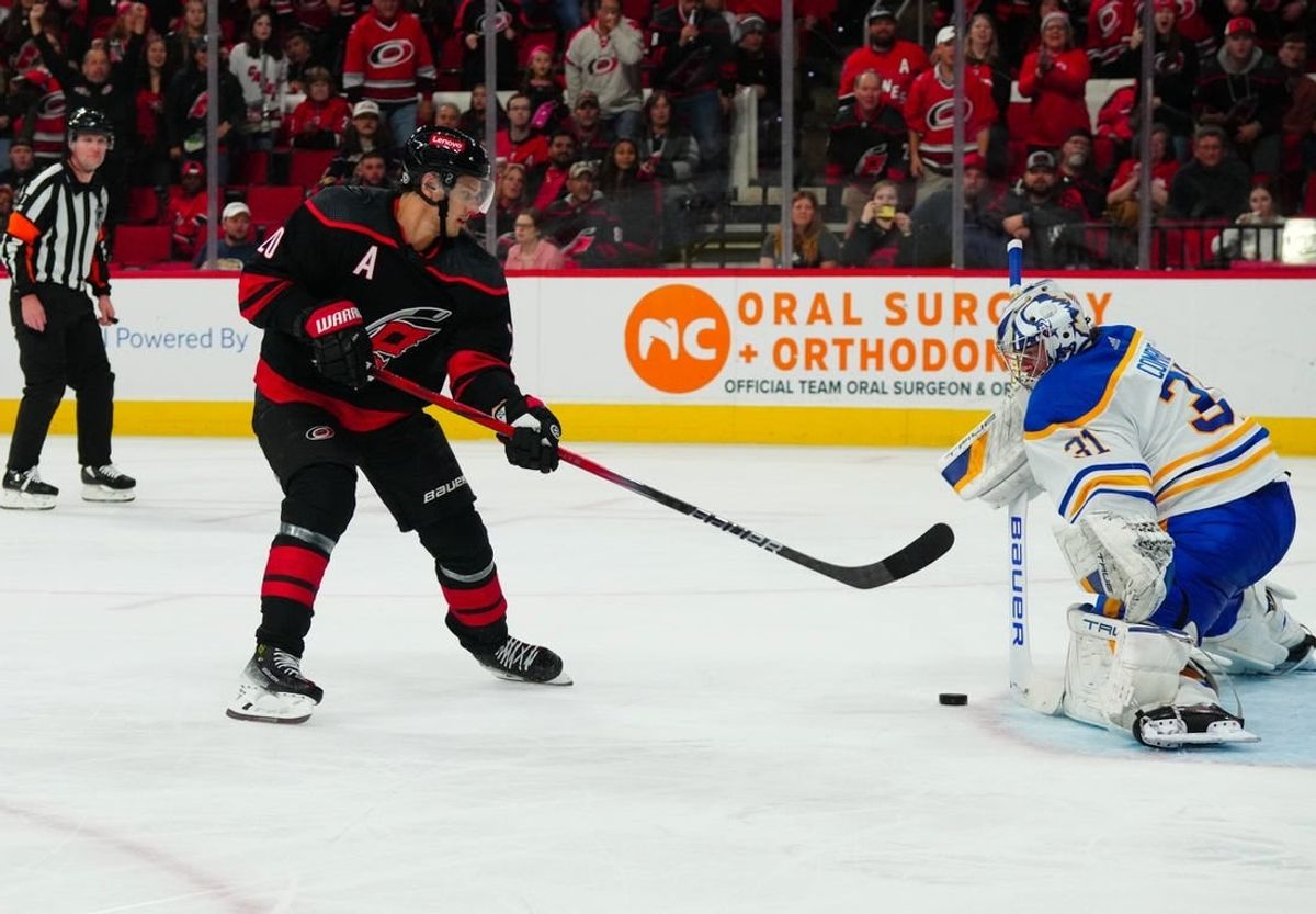 Dec 2, 2023; Raleigh, North Carolina, USA; Buffalo Sabres goaltender Eric Comrie (31) stops the scoring attempt by Carolina Hurricanes center Sebastian Aho (20) during the third period at PNC Arena.